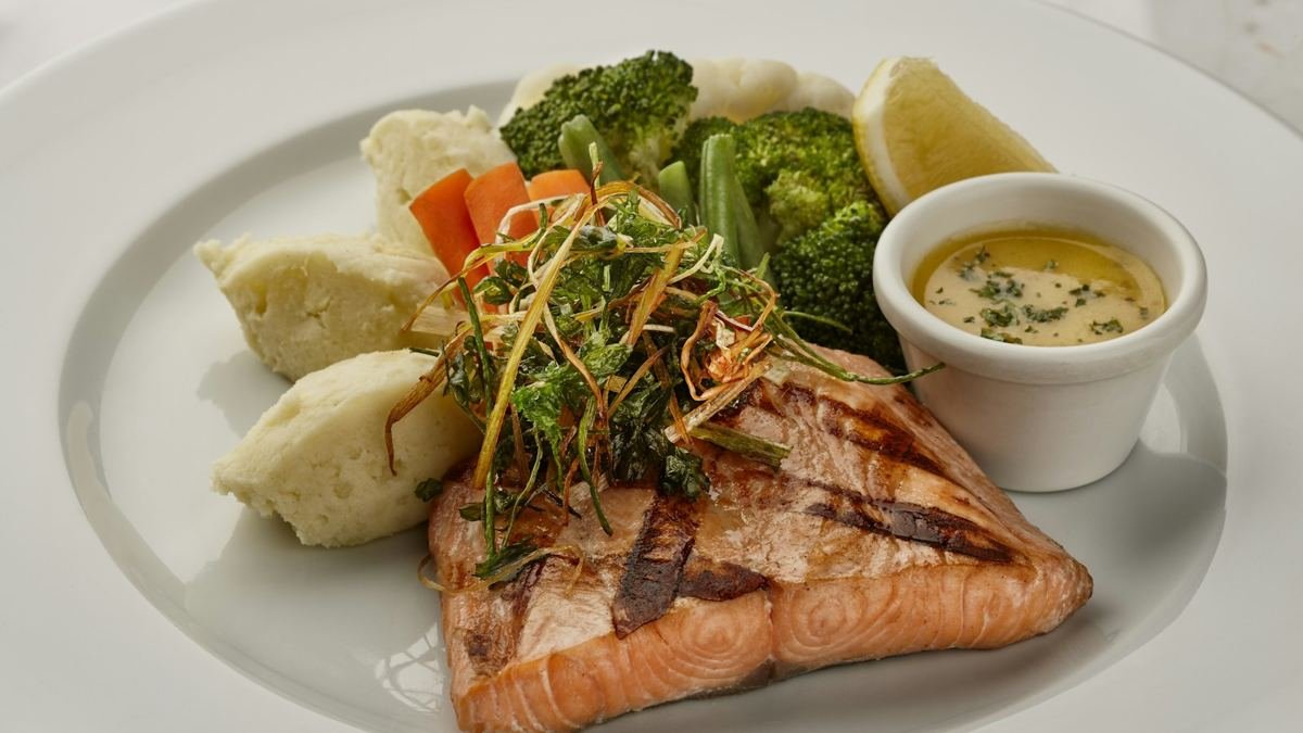 Grilled salmon with vegetables on a white plate